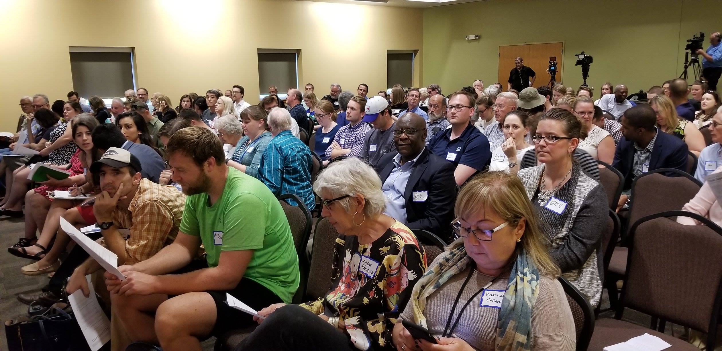 A crowd of people gather in a large meeting room for a public workshop on the Green Cincinnati plan