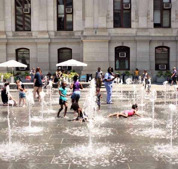 Children play in jets of water that spring up in a splash park in a city center in Philadelphia.